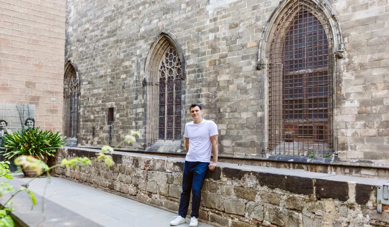 Nomadic Matt posing for a photo near an old wall in historic Barcelona, Spain